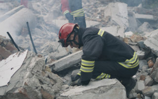 Fireman slaving civilians of a building ruins