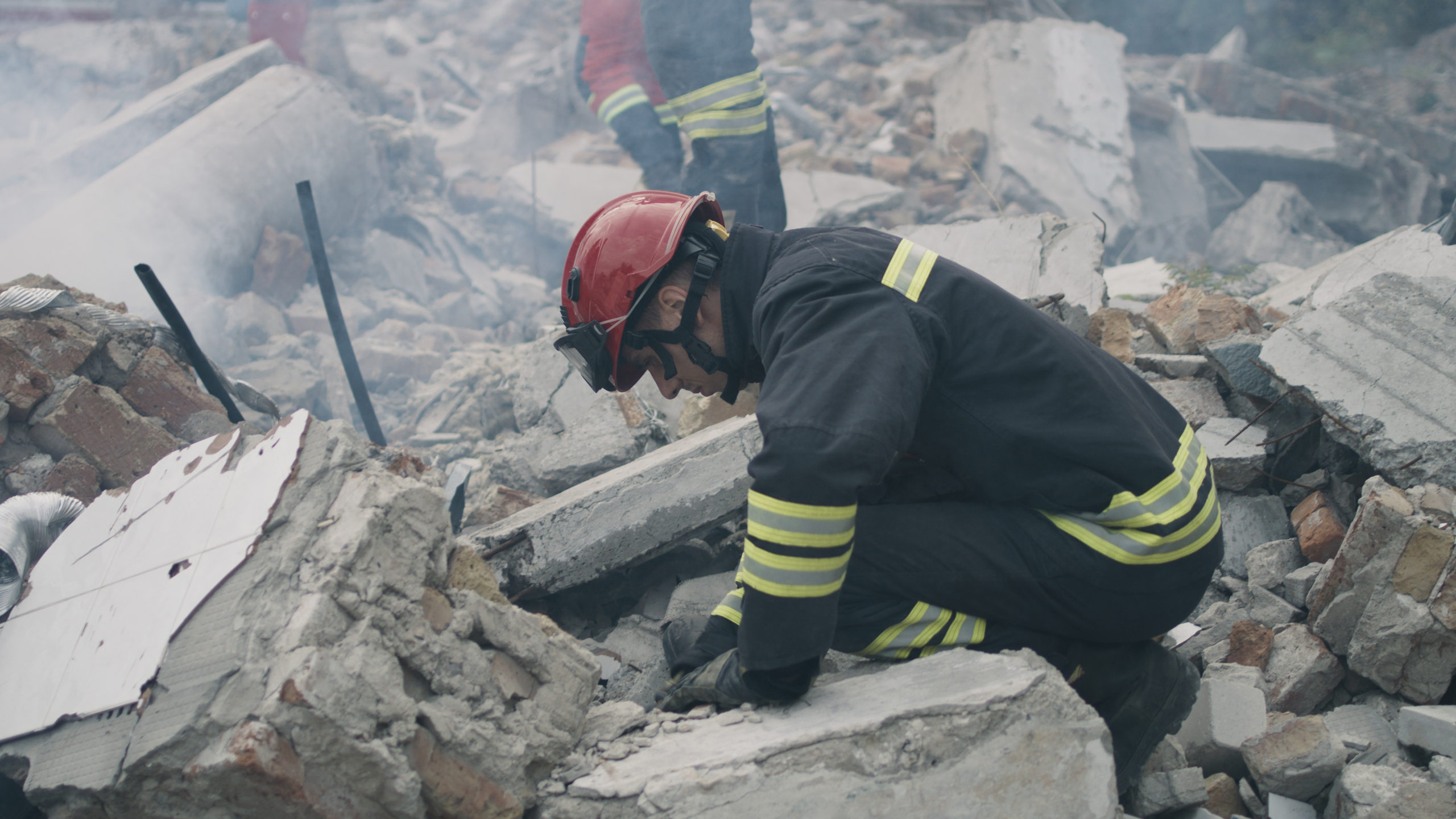 Fireman slaving civilians of a building ruins